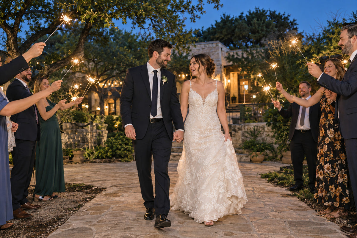 Bride and groom walking through a wedding sparkler send-off at night