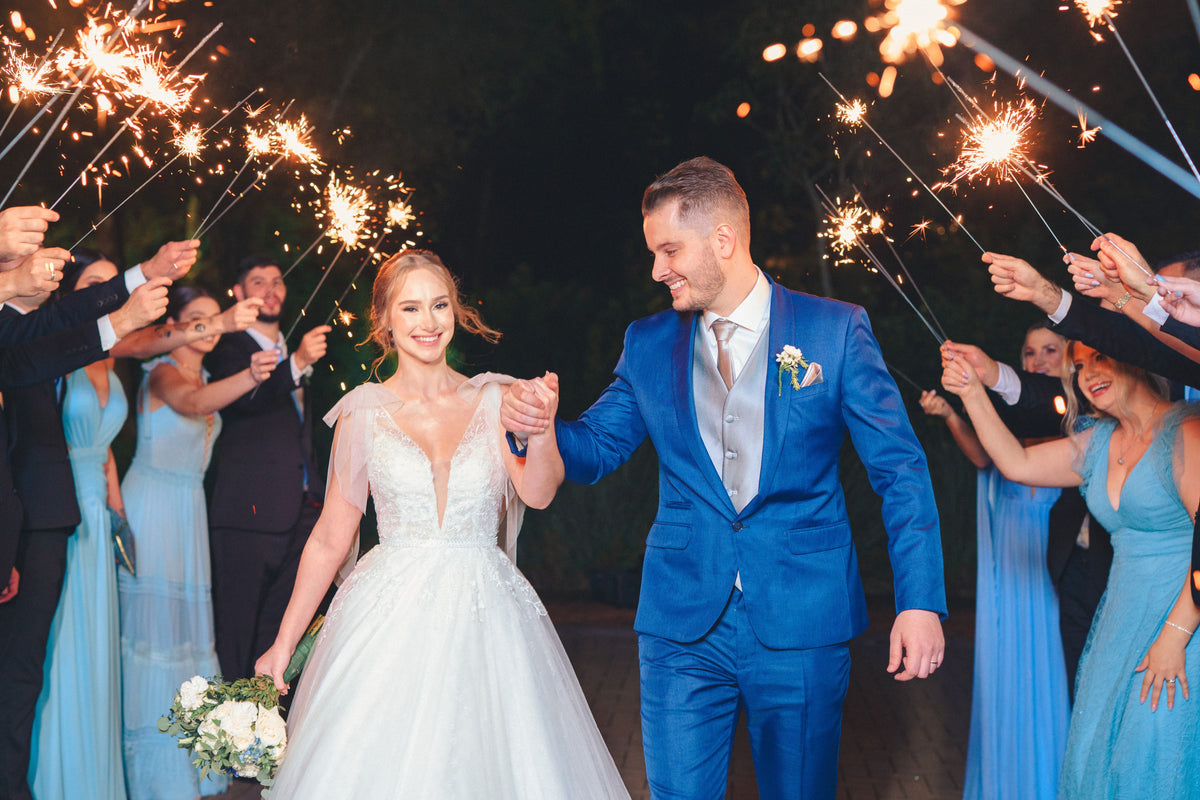 Bride and groom walking hand in hand through a wedding sparkler send-off tunnel